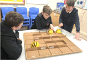 Photo of children using Bee-Bots to solve problems on a maze